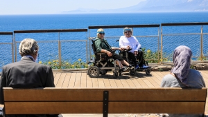 Akülü sandalyeleriyle sokağa çıkan çift, deniz hasretini giderdi