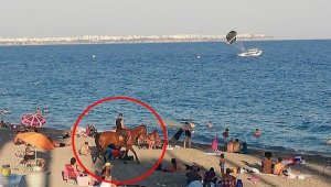 Kovboy şapkası takıp, atını denize sürdü
