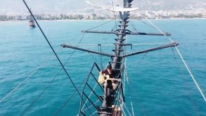 Teknenin tepesinde gitarla Alanya tanıtımı yaptı