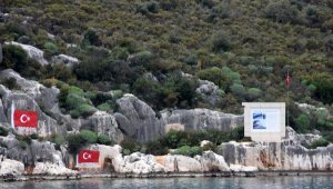 Koydaki kayalıklara işlenen 107 yıllık bayraklar yenilendi