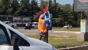 Yerde bulduğu Türk bayrağını temizleyip, tabelaya astı