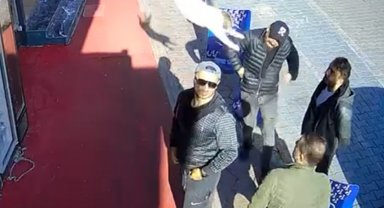 Arkadaşları ile sohbet ederken başına kedi atladı; o anlar kamerada