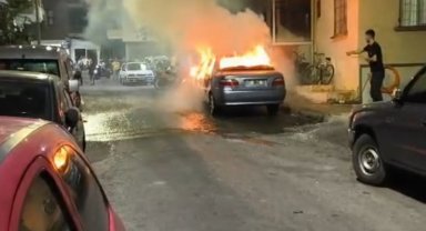 Yanan otomobili, balkondan kovalarla su dökerek söndürdüler